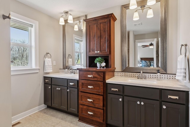 full bath featuring visible vents, two vanities, and a sink