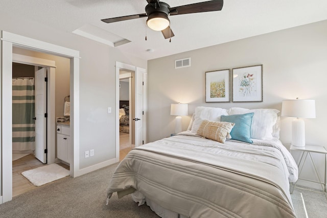 bedroom with visible vents, light carpet, baseboards, connected bathroom, and a ceiling fan