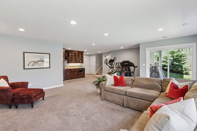 living room featuring light carpet, indoor wet bar, baseboards, stairway, and recessed lighting