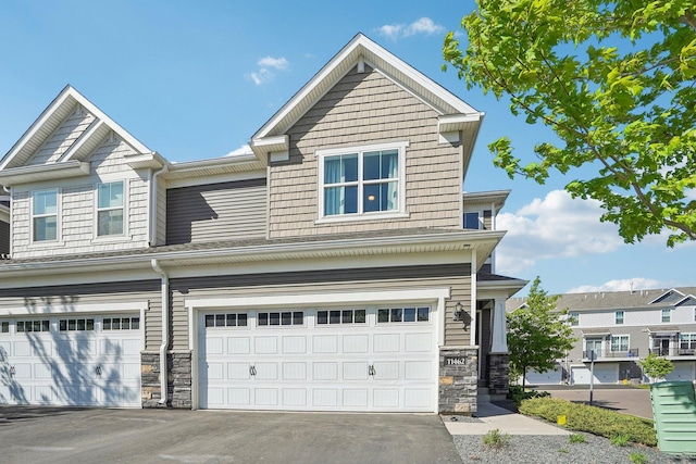 11462 81st Pl N, Maple Grove, MN 55369 - view of front of house featuring a garage, stone siding, and asphalt driveway