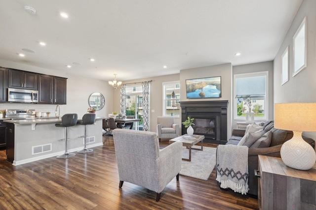 11462 81st Pl N, Maple Grove, MN 55369 - living area with dark wood-style flooring, a glass covered fireplace, recessed lighting, a chandelier, and baseboards