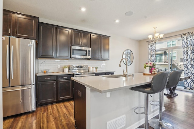 11462 81st Pl N, Maple Grove, MN 55369 - kitchen featuring appliances with stainless steel finishes, dark wood-style floors, a chandelier, tasteful backsplash, and a sink