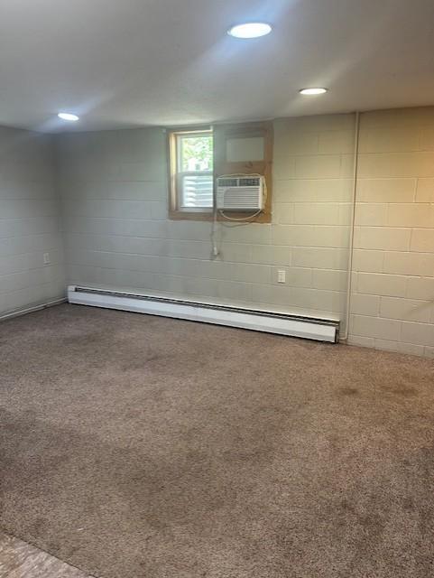627 7th Ave S, Saint Cloud, MN 56301 - below grade area with a baseboard heating unit, concrete block wall, a wall mounted AC, and carpet flooring
