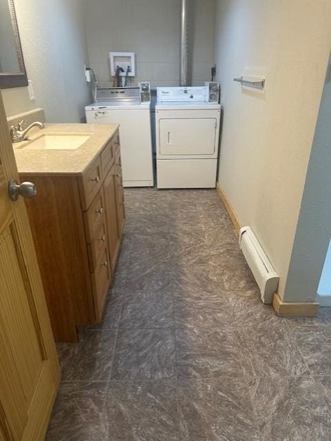 627 7th Ave S, Saint Cloud, MN 56301 - clothes washing area with washer and dryer, a baseboard heating unit, and a sink