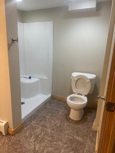 627 7th Ave S, Saint Cloud, MN 56301 - bathroom featuring baseboards, toilet, and a shower