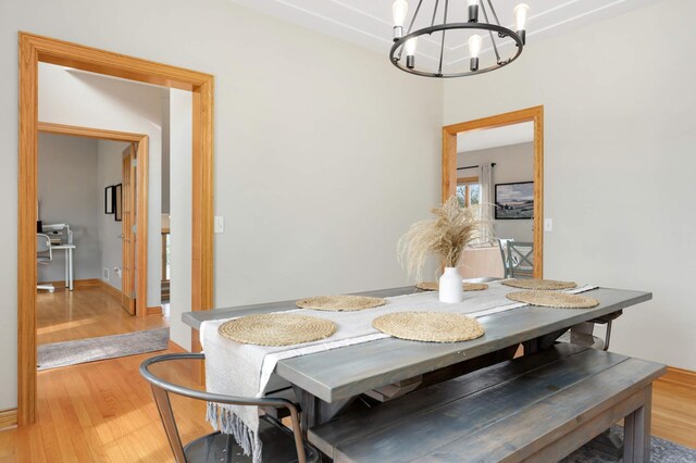 dining room with light wood-type flooring and a chandelier