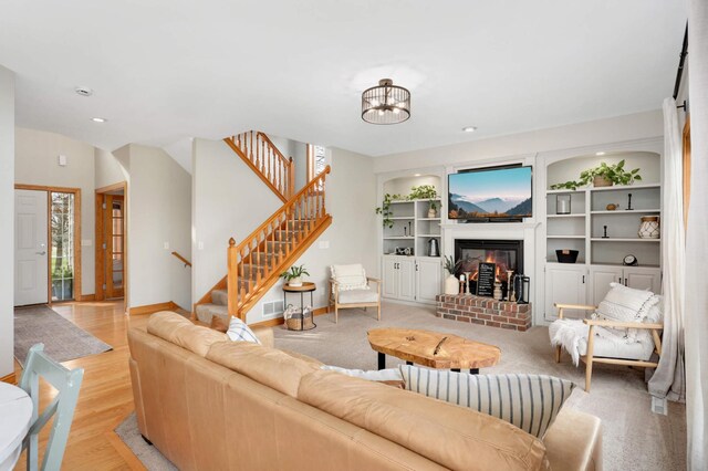 living area with a fireplace, recessed lighting, baseboards, visible vents, and stairway