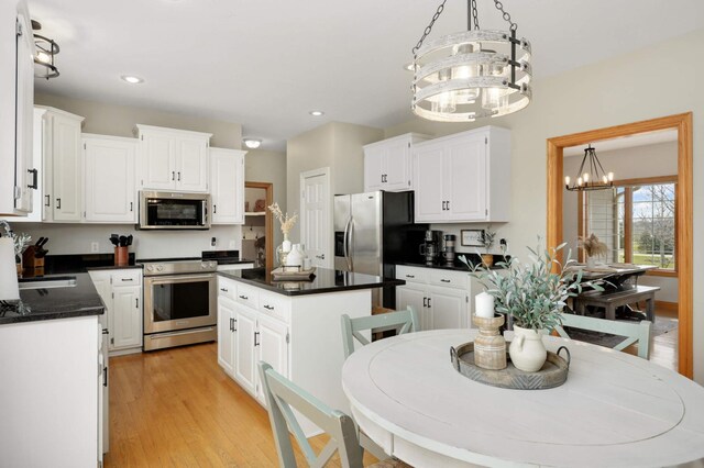 kitchen featuring dark countertops, a center island, a sink, a chandelier, and stainless steel appliances