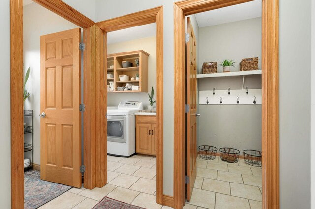 washroom with cabinet space, washer / clothes dryer, and light tile patterned flooring