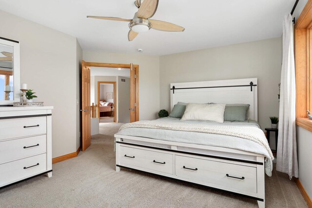 bedroom with baseboards, light carpet, and ceiling fan