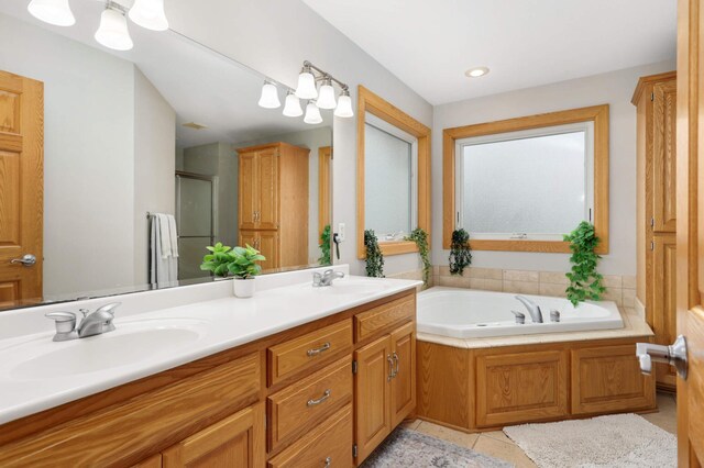 full bathroom featuring tile patterned flooring, a sink, a garden tub, and a stall shower