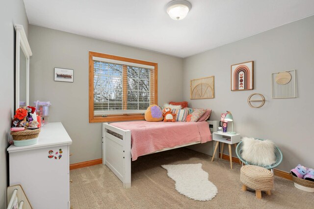 bedroom with baseboards and light colored carpet