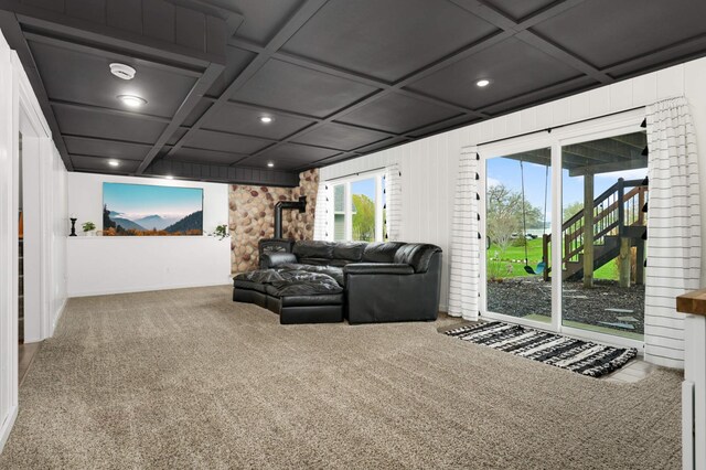 living area featuring a wood stove, carpet floors, beamed ceiling, coffered ceiling, and recessed lighting