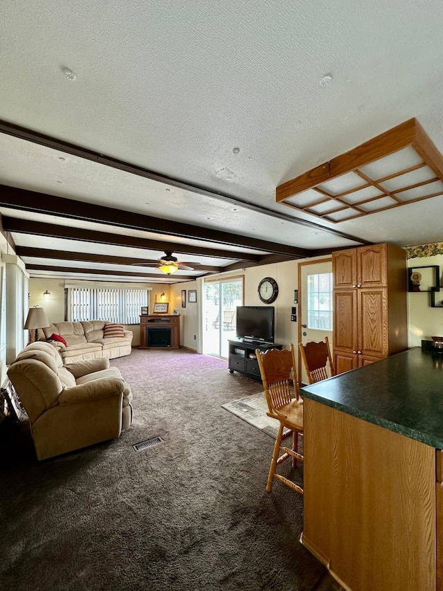 1404 Central Rd, Littlefork, MN 56653 - living area with a textured ceiling, dark colored carpet, a ceiling fan, beamed ceiling, and visible vents