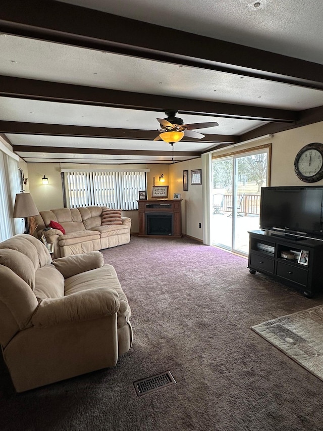 1404 Central Rd, Littlefork, MN 56653 - carpeted living area with ceiling fan, visible vents, beam ceiling, and a fireplace