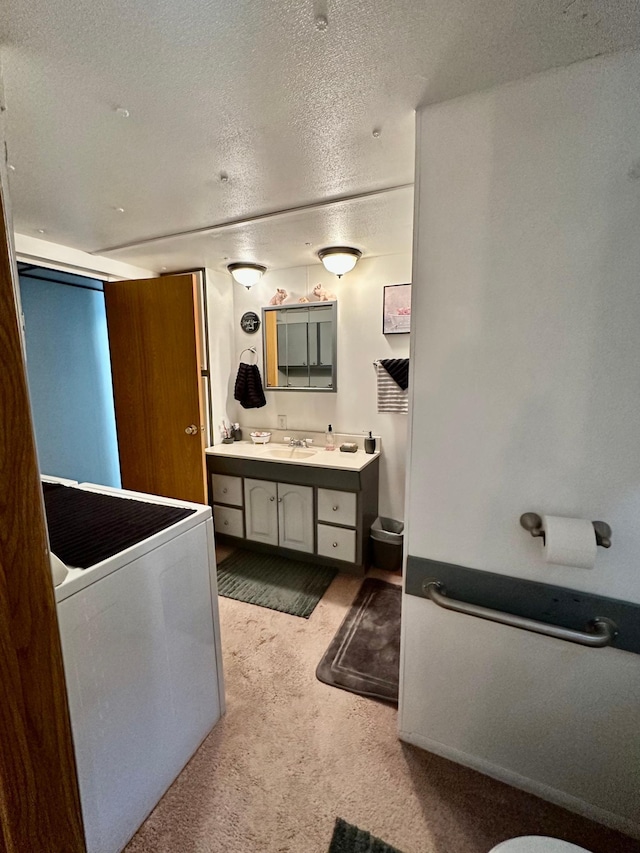 1404 Central Rd, Littlefork, MN 56653 - bathroom with vanity, a textured ceiling, and washer / clothes dryer