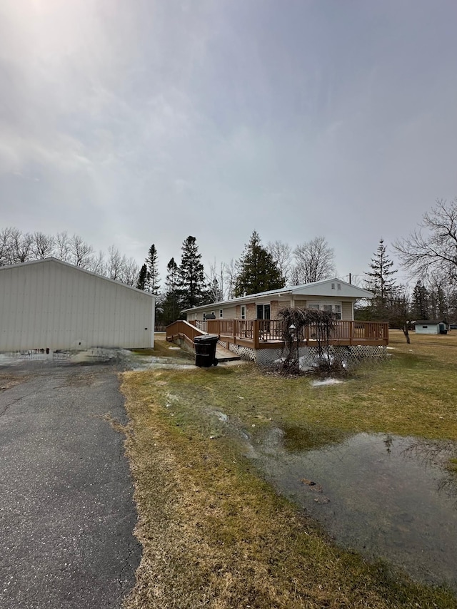 1404 Central Rd, Littlefork, MN 56653 - view of front facade featuring an outdoor structure, a front lawn, and a wooden deck