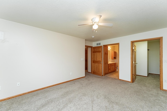 274 Dawn Ave, Saint Charles, MN 55972 - unfurnished bedroom featuring visible vents, light carpet, baseboards, ensuite bathroom, and a walk in closet