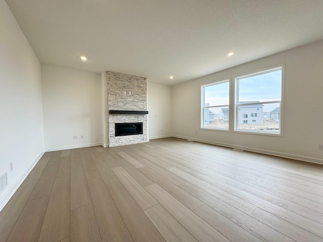 unfurnished living room with recessed lighting, dark wood finished floors, baseboards, and a fireplace