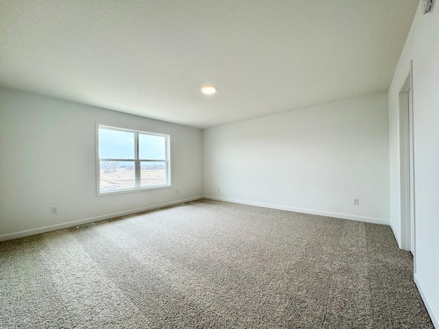 unfurnished room with baseboards and carpet flooring