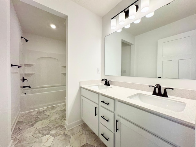 full bathroom with double vanity, a sink, baseboards, and toilet