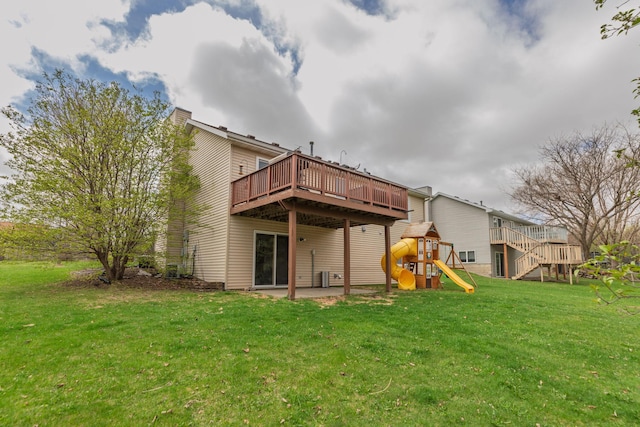 back of property with a playground, a lawn, a patio area, and a deck