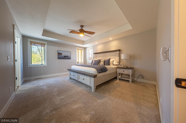 509 Superior Ave, Crosby, MN 56441 - bedroom featuring baseboards, a ceiling fan, a tray ceiling, and light colored carpet