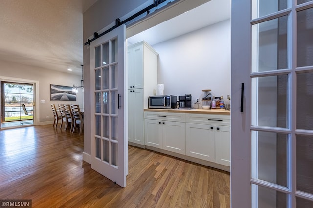 509 Superior Ave, Crosby, MN 56441 - bar featuring stainless steel microwave, a barn door, baseboards, and light wood-style floors