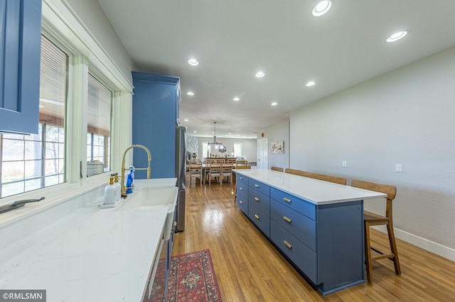 509 Superior Ave, Crosby, MN 56441 - kitchen with a sink, a kitchen breakfast bar, freestanding refrigerator, recessed lighting, and blue cabinets