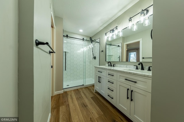 509 Superior Ave, Crosby, MN 56441 - full bath with a sink, double vanity, a shower stall, and wood finished floors