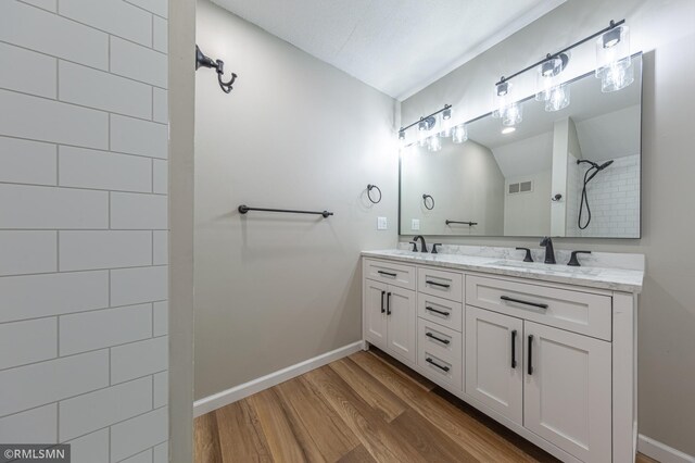 509 Superior Ave, Crosby, MN 56441 - full bath featuring tiled shower, visible vents, a sink, and wood finished floors
