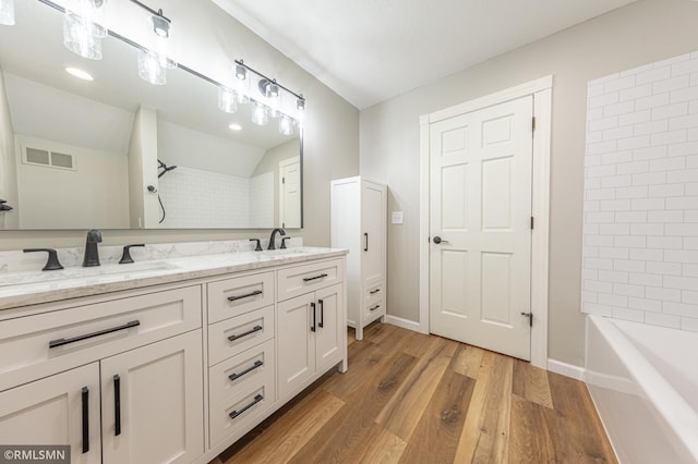 509 Superior Ave, Crosby, MN 56441 - full bath with double vanity, visible vents, a sink, and wood finished floors