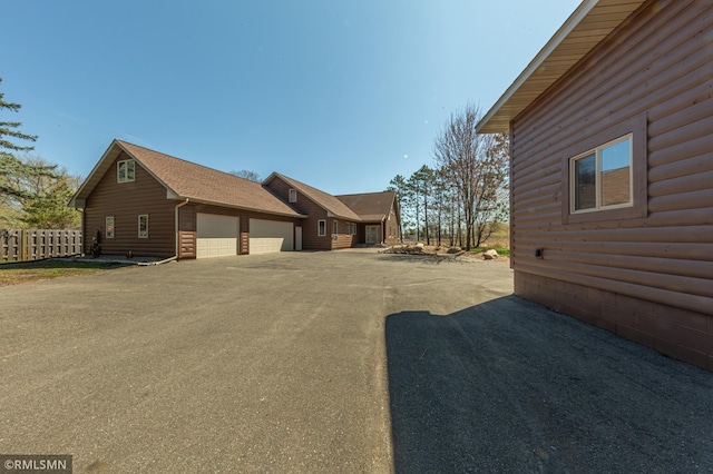 509 Superior Ave, Crosby, MN 56441 - view of side of home featuring a garage, fence, and aphalt driveway