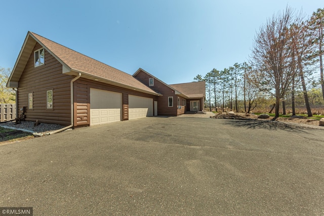 509 Superior Ave, Crosby, MN 56441 - view of side of home featuring a garage, log veneer siding, and aphalt driveway