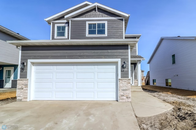 view of front facade with an attached garage, driveway, and stone siding