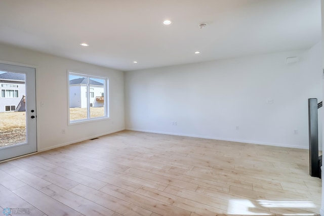 unfurnished living room featuring light wood-type flooring, recessed lighting, baseboards, and a healthy amount of sunlight