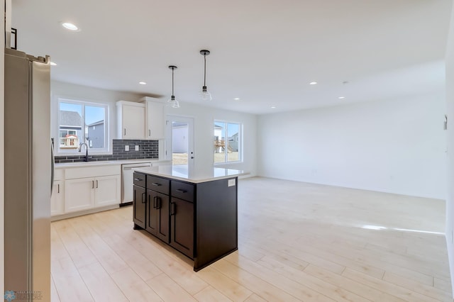 kitchen featuring a sink, white cabinets, a wealth of natural light, and stainless steel appliances