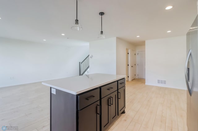 kitchen with light wood finished floors, light countertops, freestanding refrigerator, recessed lighting, and visible vents