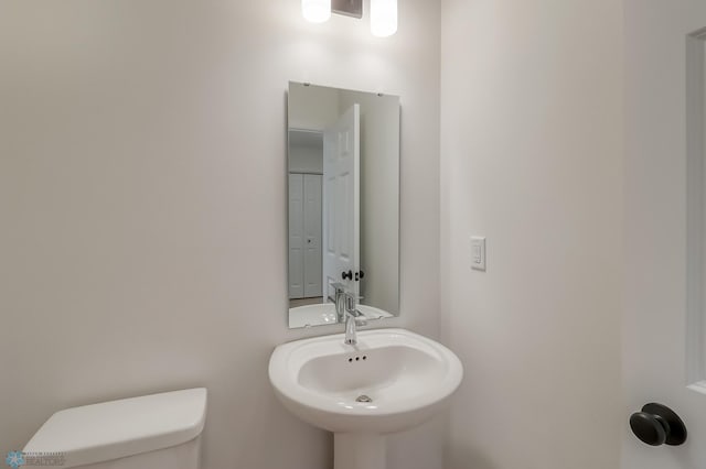 half bathroom with toilet and a sink