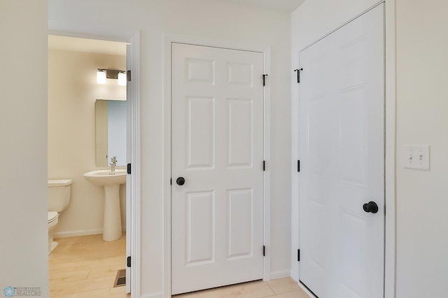 hall with baseboards and light wood finished floors