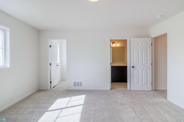 unfurnished bedroom featuring carpet floors, baseboards, a walk in closet, and visible vents