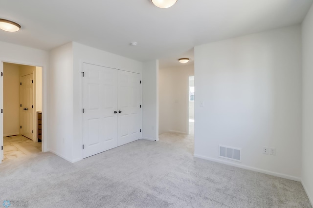 unfurnished bedroom with baseboards, carpet, a closet, and visible vents