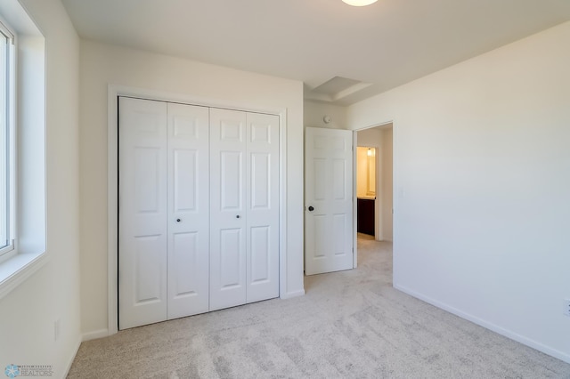 unfurnished bedroom with a closet, baseboards, and carpet flooring