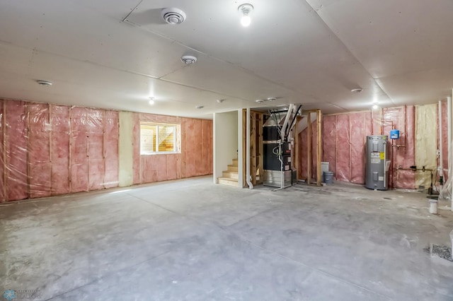 basement featuring heating unit, water heater, and stairs
