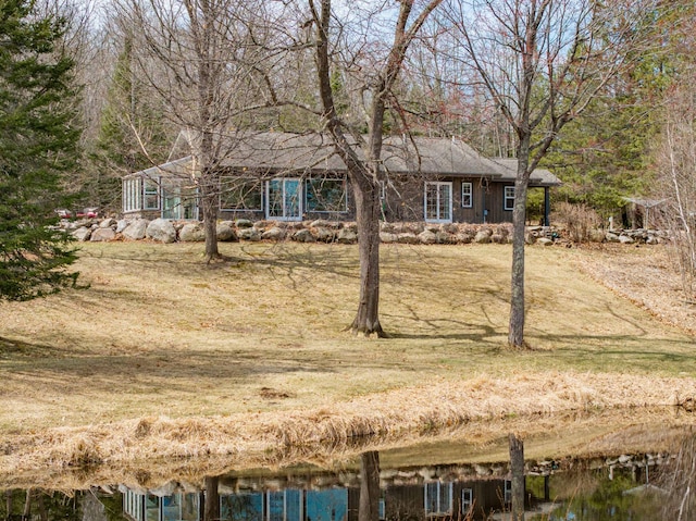view of front facade with a water view and a front lawn