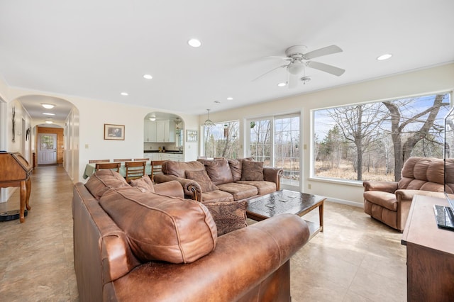 living room featuring recessed lighting, arched walkways, baseboards, and ceiling fan