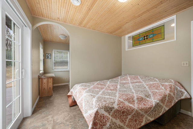 bedroom featuring baseboards, arched walkways, and wood ceiling