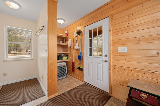 interior space with wooden walls, baseboards, and crown molding