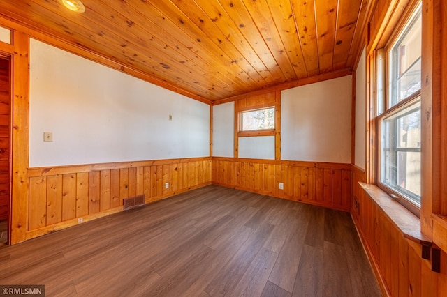 27042 Round Lake Rd, Bay Lake Twp, MN 56444 - empty room with wainscoting, wood walls, wood finished floors, and visible vents