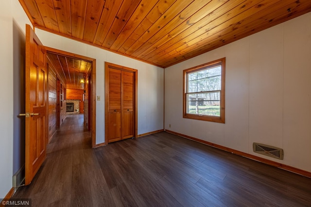 27042 Round Lake Rd, Bay Lake Twp, MN 56444 - unfurnished room featuring a fireplace, dark wood finished floors, baseboards, wooden ceiling, and visible vents